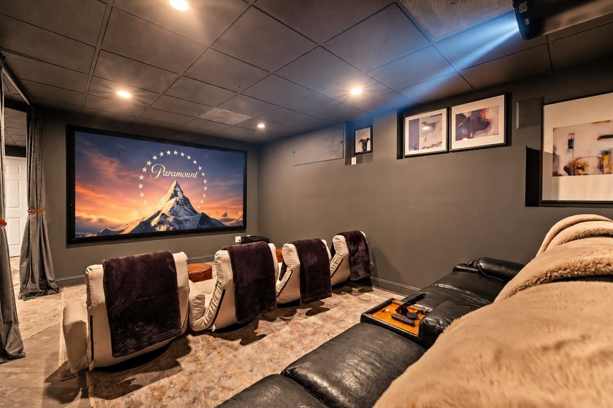 Movie night just leveled up in this dedicated home theater with plush reclining seats and a big screen.