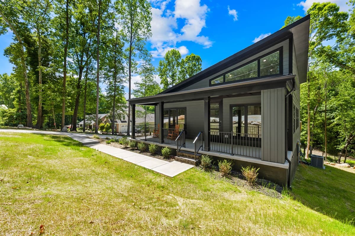 Modern meets nature at Driftwood, where massive windows and a striking black exterior blend right into the wooded lot.