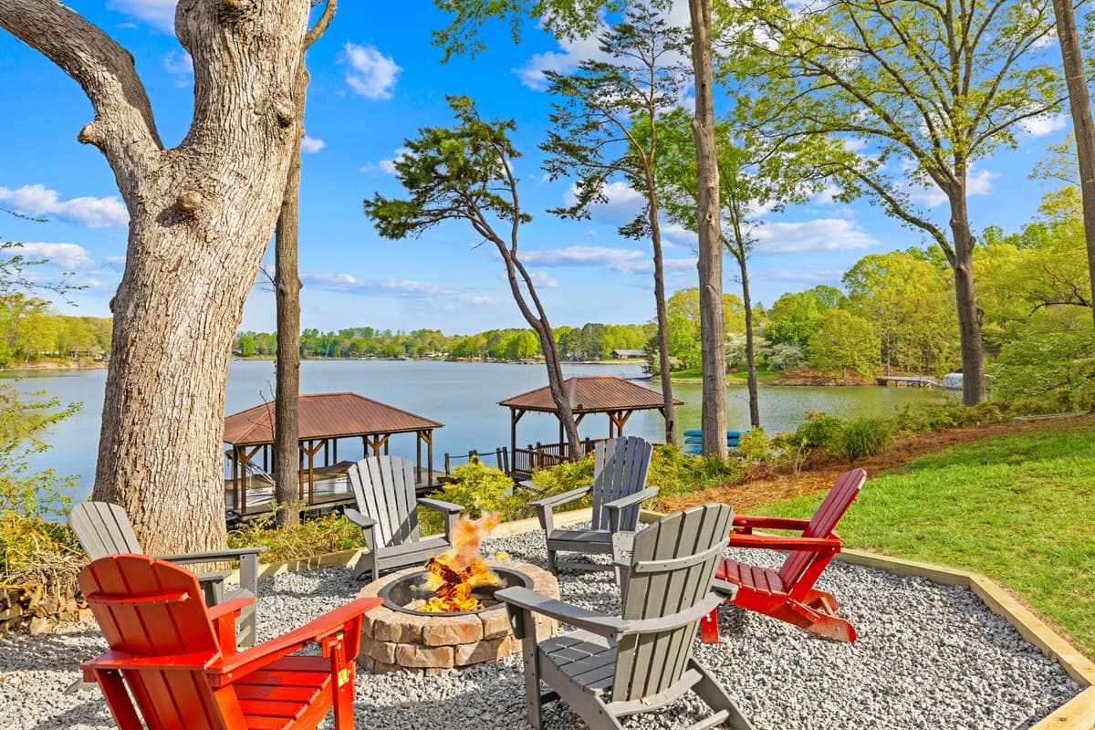 Gather around the fire pit in red Adirondack chairs, with the lake and covered dock as your backdrop.